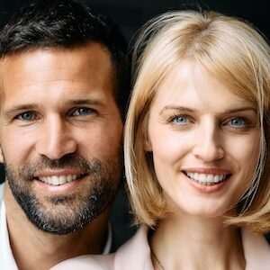 Close up of happy business couple looking at camera. Close up portrait of happy business colleagues looking at camera.